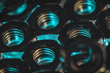 Sticker - Closeup shot of screw nuts in a dark atmosphere with blue lights coming under it