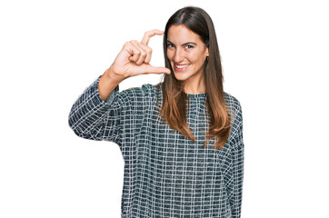 Young beautiful woman wearing casual clothes smiling and confident gesturing with hand doing small size sign with fingers looking and the camera. measure concept.