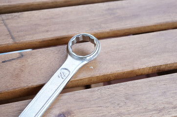 Poster - Selective focus shot of a wrench on wooden planks