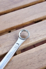 Poster - Vertical selective focus shot of a wrench on wooden planks