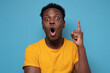 © Viktor Koldunov - Young handsome african man pointing with finger up having great idea for start up. Studio shot on blue wall