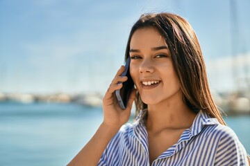 Young hispanic girl smiling happy talking on the smartphone at the port