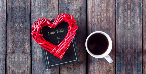 Wall Mural - Bible on the table. Holy book. Red heart. A cup on a wooden table.