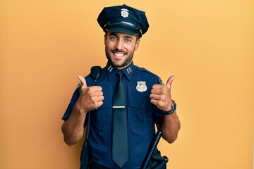 Poster - Handsome hispanic man wearing police uniform success sign doing positive gesture with hand, thumbs up smiling and happy. cheerful expression and winner gesture.