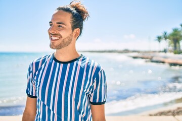 Sticker - Young hispanic man smiling happy looking to the side at city.