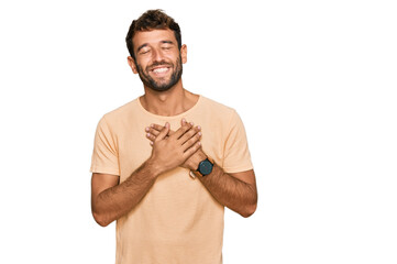 Poster - Handsome young man with beard wearing casual tshirt smiling with hands on chest with closed eyes and grateful gesture on face. health concept.