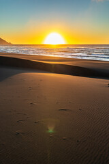 Wall Mural - an amazing sea view during sunset time of an awe sandy beach full of sand dunes till the infinite. i