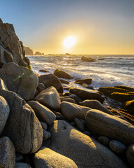 Wall Mural - an awe sunset in an idyllic beach landscape with the sunset over the water and the sunlight generati