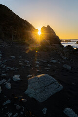 Wall Mural - an awe sunset in an idyllic beach landscape with the sunset over the water and the sunlight generati