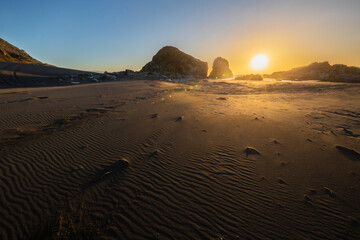 Wall Mural - an awe sunset in an idyllic beach landscape with the sunset over the water and the sunlight generati
