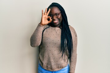 Sticker - Young black woman with braids wearing casual clothes and glasses smiling positive doing ok sign with hand and fingers. successful expression.