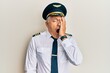 Handsome middle age mature man wearing airplane pilot uniform yawning tired covering half face, eye and mouth with hand. face hurts in pain.