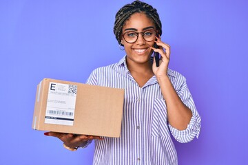 Poster - Young african american woman with braids holding delivery box calling assistance smiling with a happy and cool smile on face. showing teeth.