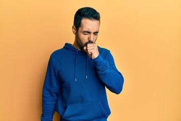 Wall Mural - Young hispanic man wearing casual clothes feeling unwell and coughing as symptom for cold or bronchitis. health care concept.