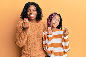 Poster - Beautiful african american mother and daughter wearing wool winter sweater doing money gesture with hands, asking for salary payment, millionaire business