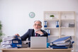 © Elnur - Aged male employee unhappy with excessive work