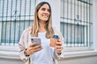 © Krakenimages.com - Young caucasian woman smiling happy using smartphone and drinking take away coffee at the city.