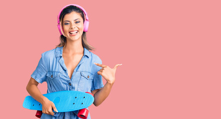 Poster - Young beautiful woman wearing headphones and holding skate pointing finger to one self smiling happy and proud