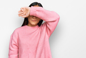 Wall Mural - Young asian woman wearing casual winter sweater covering eyes with arm, looking serious and sad. sightless, hiding and rejection concept