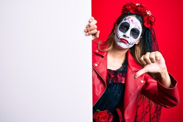 Sticker - Woman wearing day of the dead costume holding blank empty banner with angry face, negative sign showing dislike with thumbs down, rejection concept