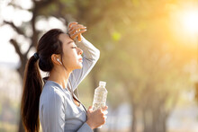Young Woman Drinking Water After Jogging