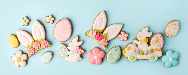 Wall Mural - Happy Easter set of cookies 2021, gingerbread funny bunny, flowers, eggs from ginger biscuits glazed sugar icing decoration on blue background, minimal seasonal springtime banner, copy space