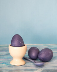 Wall Mural - Painted purple eggs and a porcelain spoon in the color of eggs