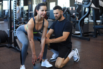 Wall Mural - Fitness instructor exercising with his client at the gym.