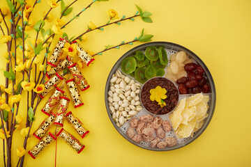 Wall Mural - Firecrackers with best wishes inscription, blooming apricot branches and tin round box of dried fruits and nuts prepared for Chinese New Year