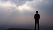 © TS.PHOTOS - Silhouette of man standing alone on the mountain top looking at sky and sunset view Solo travel and new day inspirational concept