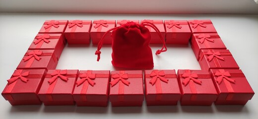 Frame, rectangle from red gift boxes with red gift bag in the middle. 3D perspective.