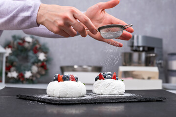 Process of making berry cakes. Cakes Anna Pavlova and hands of confectioner