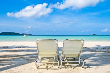 Wall Mural - Two white beach chairs on tropical sandy beach