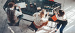 © Alex from the Rock - Group of young business people in bright office working together and sitting near big black desk. Video call conference. Wide screen