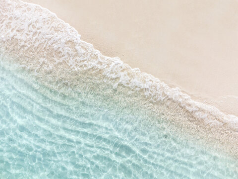 aerial top view of beautiful tropical white sand beach with wave foam and transparent sea, summer va