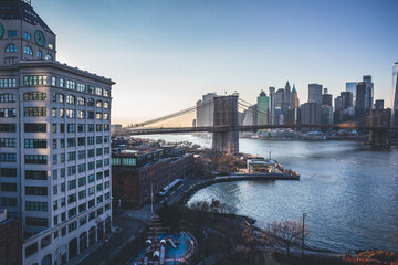 Wall Mural - New York City skyline with skyscrapers at sunset. Brooklyn bridge as a connection between Manhattan and Brooklyn