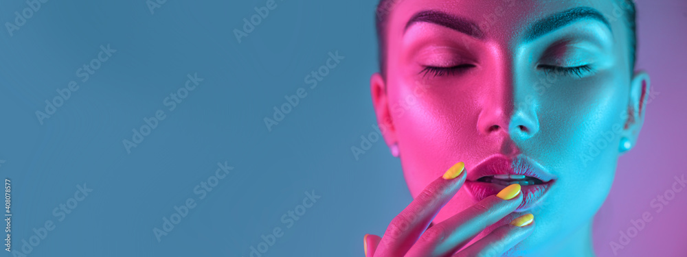 High Fashion model girl in colorful bright UV lights posing in studio, portrait of beautiful woman with trendy make-up and manicure. Art design, colorful make up. Over colourful background - obrazy, fototapety, plakaty 
