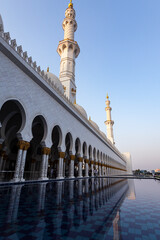 Side view of Grand Mosque, UAE. The pool inside the mosque and two minarets are visible.