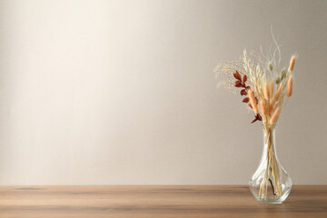 Canvas Print - Dried flowers in vase on table against light background. Space for text