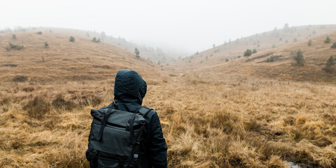 Wall Mural - Young man exploring nature on a wet winter morning in the mountains