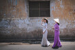 Young Vietnam woman wearing Ao Dai culture traditional walking on local street at Ho Chi Minh in Vietnam,vintage style,travel and relaxing concept.