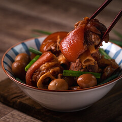 Wall Mural - Eating Taiwanese food pork knuckle in a bowl with chopsticks