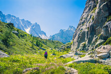 Hiker Walking Up To The Fenetre D'Aprette Through A Valley Along  Rock Stone Wall, Tour Du Mont Blanc, Switzerland