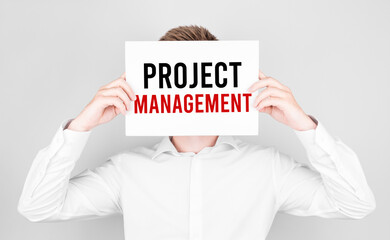 Poster - man covers his face with a white paper with text project management