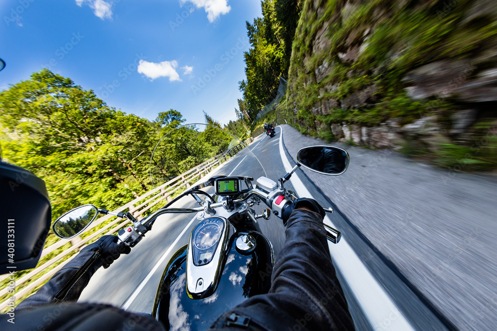 POV of motorbiker holding steering bar, riding in Alps in beautiful dramatic sky. Travel and freedom, outdoor activities - obrazy, fototapety, plakaty 