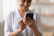 © fizkes - Cropped shot of happy smiling millennial indian female confident cellphone user enjoying using new device surfing websites order goods online. Focus on smartphone gadget in young woman hands. Close up