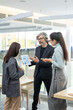© pressmaster - Two young elegant businesswomen listening to mature business partner with tablet