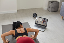 Young Fit Woman Athlete In Sportswear Doing Workout On Mat Online Looking At Coach On Screen During Video Lesson At Home. Active Healthy Lifestyle, Training At Home And Online Training Concept