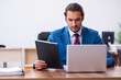 © Elnur - Young male employee working at workplace