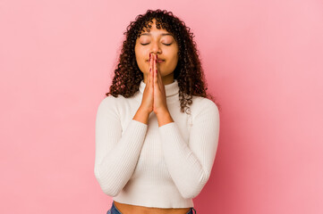 Young african american afro woman isolated holding hands in pray near mouth, feels confident.